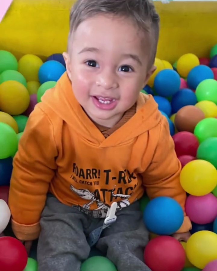 Bebê sorrindo na piscina de bolinhas