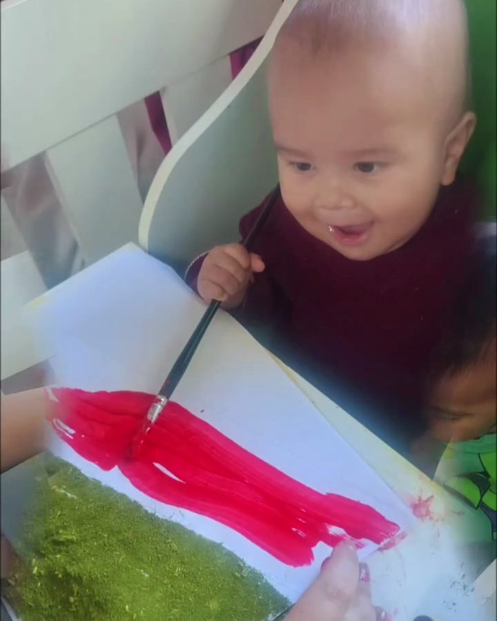 Bebê pintando a bandeira do Rio Grande do Sul com tinta e erva-mate